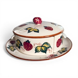 May include: A white ceramic mug with a black handle and the text "But First, Coffee" in a bold, black font. The mug is set against a blurred background, highlighting its clean design.