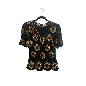 Blusa vintage de seda negra Stenay de los años 80 con flores de lentejuelas doradas y hojas con cuentas, talla M