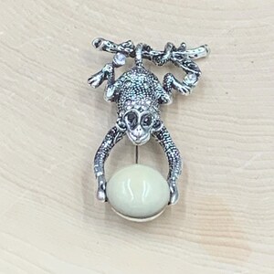 Silver toned monkey brooch
