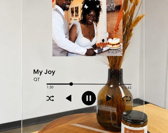 May include: A clear rectangular acrylic plaque featuring a printed photograph of a couple cutting a cake. The design includes black text reading My Joy and QT, a playback progress bar at 1:30 of 3:43, and standard music player control icons.