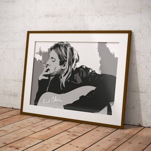 Può includere: Ritratto in bianco e nero di un musicista che suona la chitarra. Il musicista indossa una giacca di pelle e ha i capelli lunghi. L'immagine è incorniciata in una cornice di legno marrone.