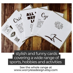 May include: A collection of white greeting cards with black text, featuring humorous definitions and phrases related to sports and hobbies. The cards are displayed on a wooden surface. Text on the cards includes "Cricket", "All You Need is Love", and "I Love You Slightly More Than You Love Your Bike".