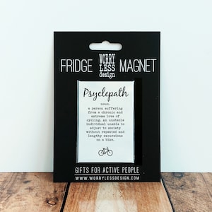 May include: Black fridge magnet with the word "Psyclepath" and a definition about cycling enthusiasts. The magnet is on a black backing with the words "Fridge Magnet" and "Gifts for Active People".