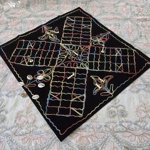 美しく刺繍された布製バルジス ゲーム、黒のベルベットの花のモチーフ。真鍮のポーン 8 個、カウボーイ シェル 6 個。サイズ 17.7 x 17.7 インチ。ファミリー ゲーム。