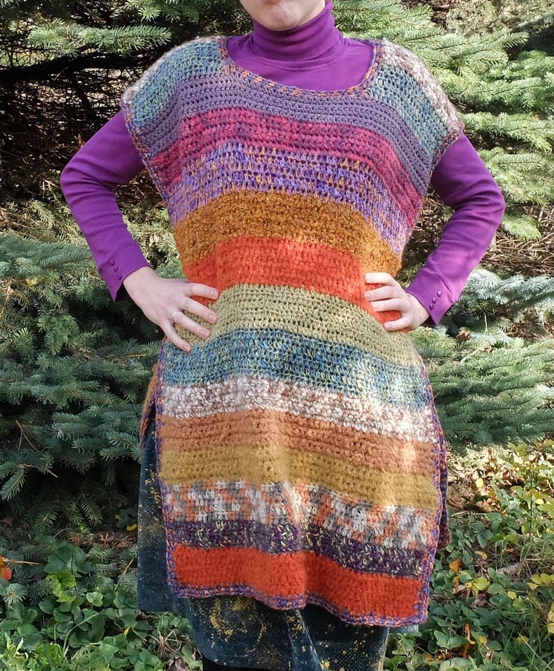 May include: A multi-colored striped crochet top with a long, loose fit. The top is made with a variety of yarns in shades of purple, pink, orange, brown, green, and blue.