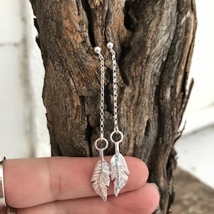Silver feather dangly earrings.