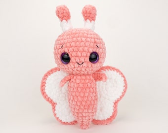 May include: A pink crocheted butterfly plush toy with white wings and large purple eyes. 