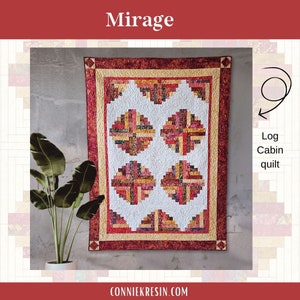 May include: A log cabin quilt with a white background and a red, orange, and yellow pattern. The quilt is called "Mirage" and is a log cabin quilt.