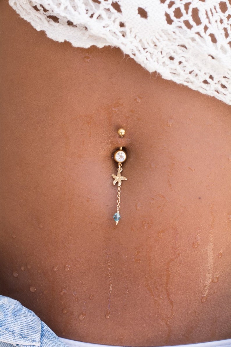 Piercing per ombelico con stella marina riempita in oro 14K e una perla di cristallo Swarovski azzurro, i gioielli per il corpo di cui hai bisogno quest'estate immagine 2