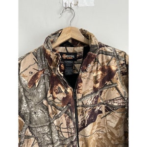 May include: A brown, green, and tan camouflage jacket with a black zipper and a black label that reads "Outfitters Ridge".