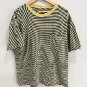 Pode incluir: Uma t-shirt de manga curta com um padrão de riscas horizontais finas em azul escuro e amarelo. A peça tem um decote redondo canelado em amarelo sólido e um bolso de chapa único localizado no lado esquerdo da zona do peito.