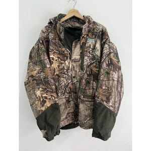 May include: Camouflage jacket with a green logo that says "Yukon Gear". The jacket has a hood and a zipper closure.