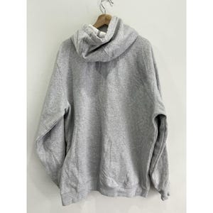 May include: A grey hooded sweatshirt with a pouch pocket. The sweatshirt has long sleeves and a drawstring hood.