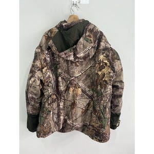 May include: Camouflage jacket with a hood and zipper closure. The jacket is made of a water-resistant material and has a drawstring hood.