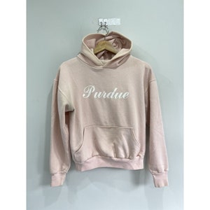 May include: A light pink hoodie with a white embroidered logo that says "Purdue".