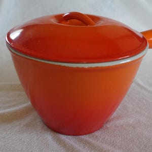 Saucepan and lid in orange enamelled cast iron from Le Creuset, Made in France