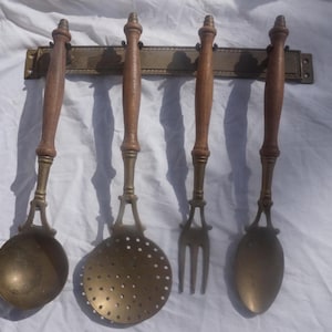 Yellow copper or brass  rack with 4 copper  kitchen utensils, a ladle, a skimmer, a fork, a spoon
