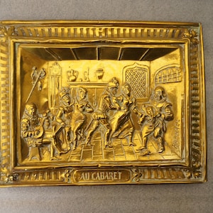 A brass board &quot; Au Cabaret &quot; signed Raphael