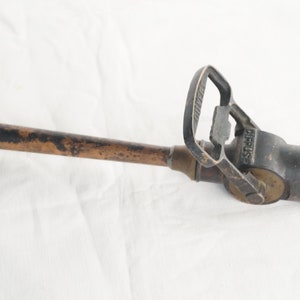May include: A vintage brass fire hose nozzle with a handle and the word "SIRIUS" embossed on the side.