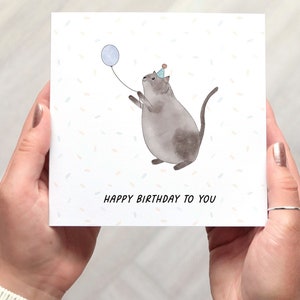 Cat Birthday Card, square birthday card with a cute cat illustration, the cat holds a balloon in this fun whimsical design