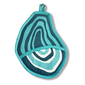 May include: Teal and navy blue oven mitt with a unique, abstract design. The mitt features a loop for hanging and a pocket for the hand. The pattern includes curved lines in shades of teal, navy, and white, creating a layered effect.
