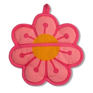 Può includere: Un presina a forma di fiore rosa con un anello per appenderla. Il centro è giallo e i petali sono rosa chiaro con accenti rosa scuro. La presina è in tessuto e ha un design cucito.