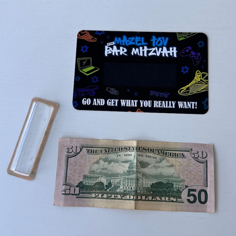 May include: A black card with a colourful design featuring a skateboard, a laptop, and a video game controller. The text "Mazel Tov Bar Mitzvah" is written in a graffiti style font. The card also includes the text "Go and get what you really want!" and a blank space for a gift card amount.