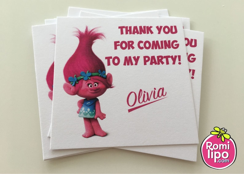 May include: Thank you for coming to my party!  A pink Trolls character with blue eyes and a flower crown is on a white thank you card with the name Olivia.