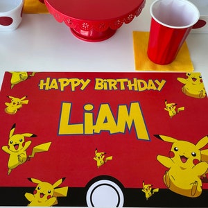 May include: Red and yellow birthday placemat with the text "Happy Birthday Liam" and a cartoon Pikachu design.