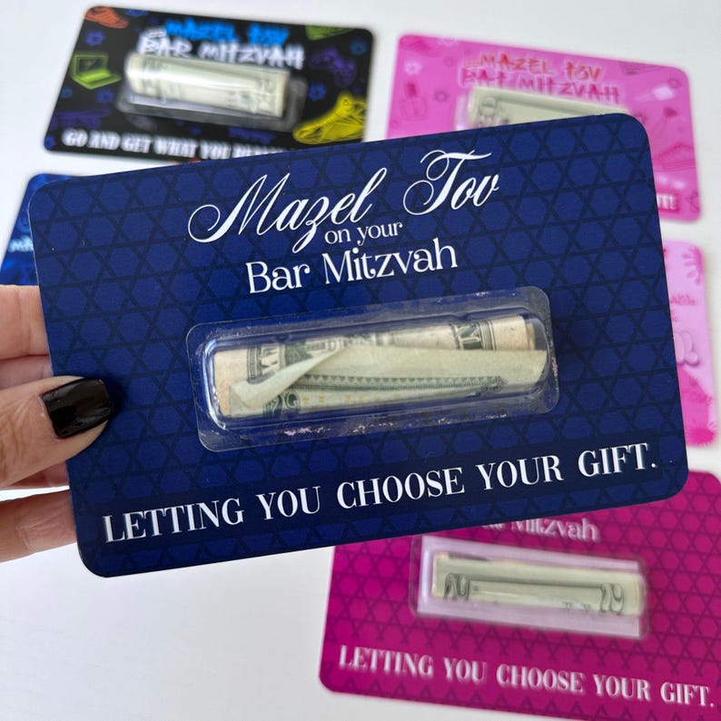 May include: A blue card with a Star of David pattern and the text "Mazel Tov on your Bar Mitzvah" with a clear plastic window showing rolled up cash. The text "Letting you choose your gift." is at the bottom of the card.