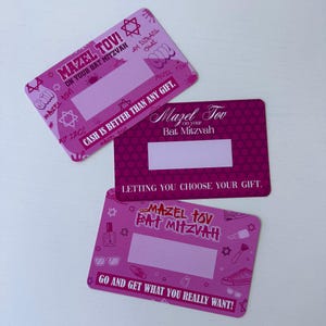 May include: Three pink and white cards with a Star of David design. The cards have the text "Mazel Tov! On your Bat Mitzvah" and "Cash is better than any gift."  The cards have a blank space for writing a message.