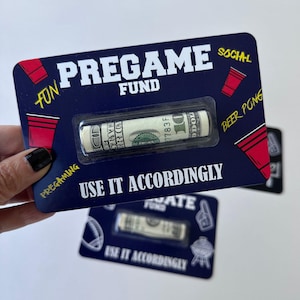 May include: A navy blue card with the text "PREGAME FUND" and "USE IT ACCORDINGLY". A rolled-up $100 bill is visible in a clear plastic blister pack. Red cup illustrations and the words "FUN", "PREGAMING", "SOCIAL", and "BEER PONG" are also present.