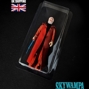 May include: A plastic action figure of a bearded character with a white head, wearing a long red coat over a black shirt, holding a thin blue rod. The figure is encased in a clear plastic blister pack. The text SKYWAMPA and WWW.SKYWAMPA.COM appear.