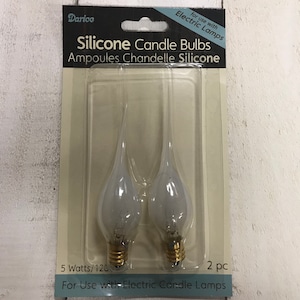 May include: Two white silicone candle bulbs, 5 watts, 120 volts, for use with electric candle lamps. The package says "Darice Silicone Candle Bulbs Ampoules Chandelle Silicone" and "For Use with Electric Candle Lamps".