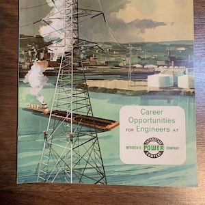 May include: Vintage advertisement for Interstate Power Company. The illustration depicts a high-voltage power tower, a barge on a river, and a cityscape in the background. The text reads "Career Opportunities for Engineers at Interstate Power Company."