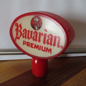 May include: Red and white oval-shaped beer tap handle with the words "Bavarian Premium" in red lettering.