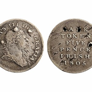 Puede incluir: Una moneda de plata con un retrato del rey Jorge III en un lado y el texto "BANK TOKEN FIVE PENCE IRISH 1805" en el otro.