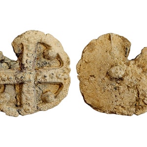 May include: A lead seal with a cross design. The seal is broken and has a rough, aged texture.