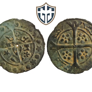 Puede incluir: Dos monedas antiguas de bronce con diseños intrincados. Una moneda presenta una cruz y patrones florales, mientras que la otra muestra una cruz con patrones circulares. Las monedas tienen una apariencia desgastada, lo que sugiere edad e importancia histórica.