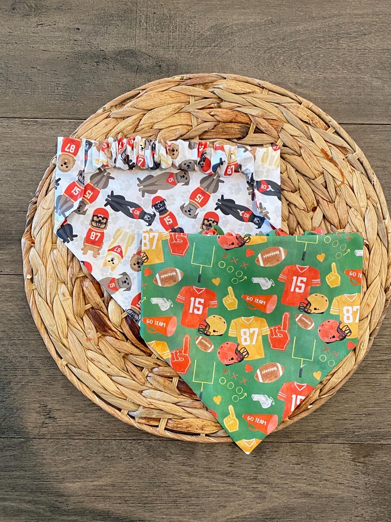 K&ouml;nnte beinhalten: Zwei Hunde-Bandanas mit Football-Mustern. Eines ist wei&szlig; mit Footballspielern, Helmen und den Nummern 15 und 87. Das andere ist gr&uuml;n mit Footb&auml;llen, Trikots, Helmen und den Nummern 15 und 87. Beide haben die Aufschrift "GO TEAM".
