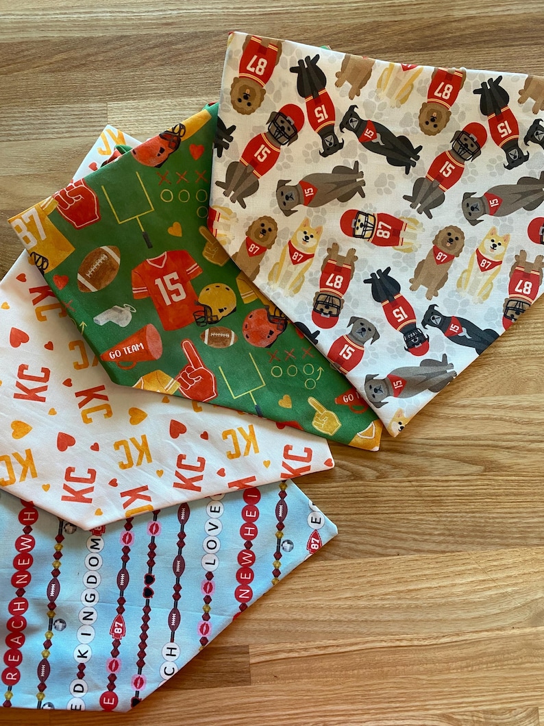 K&ouml;nnte beinhalten: Eine Auswahl an Hunde-Bandanas mit verschiedenen Mustern. Eines zeigt Football-Grafiken mit der Nummer 15, ein anderes zeigt Hunde-Illustrationen in Football-Trikots mit den Nummern 15 und 87. Andere Bandanas haben den Text "KC", "REACH NEW" und "LOVE".