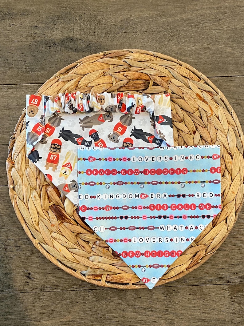 K&ouml;nnte beinhalten: Drei Hunde-Bandanas mit verschiedenen Mustern. Eines ist wei&szlig; mit Football-Hunden und der Nummer 87. Ein weiteres ist hellblau mit dem Text "REACH NEW HEIGHTS" und "LOVERS IN KC". Das dritte Bandana hat ein &auml;hnliches Muster.