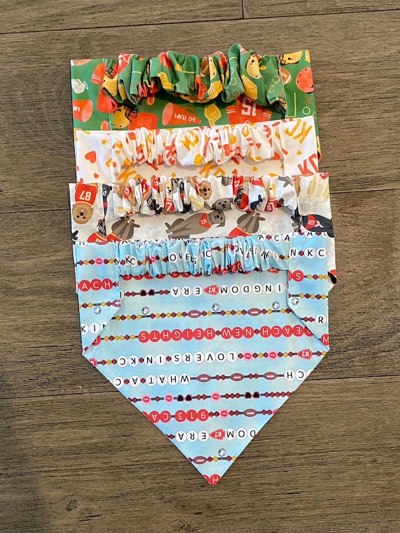 K&ouml;nnte beinhalten: Ein Stapel aus vier Haustier-Bandanas und Scrunchies mit verschiedenen Mustern. Der obere Scrunchie ist gr&uuml;n mit Football-Grafiken. Die Bandanas zeigen Football-Designs, einschlie&szlig;lich Text und Teamlogos. Das untere Bandana ist hellblau mit Text.