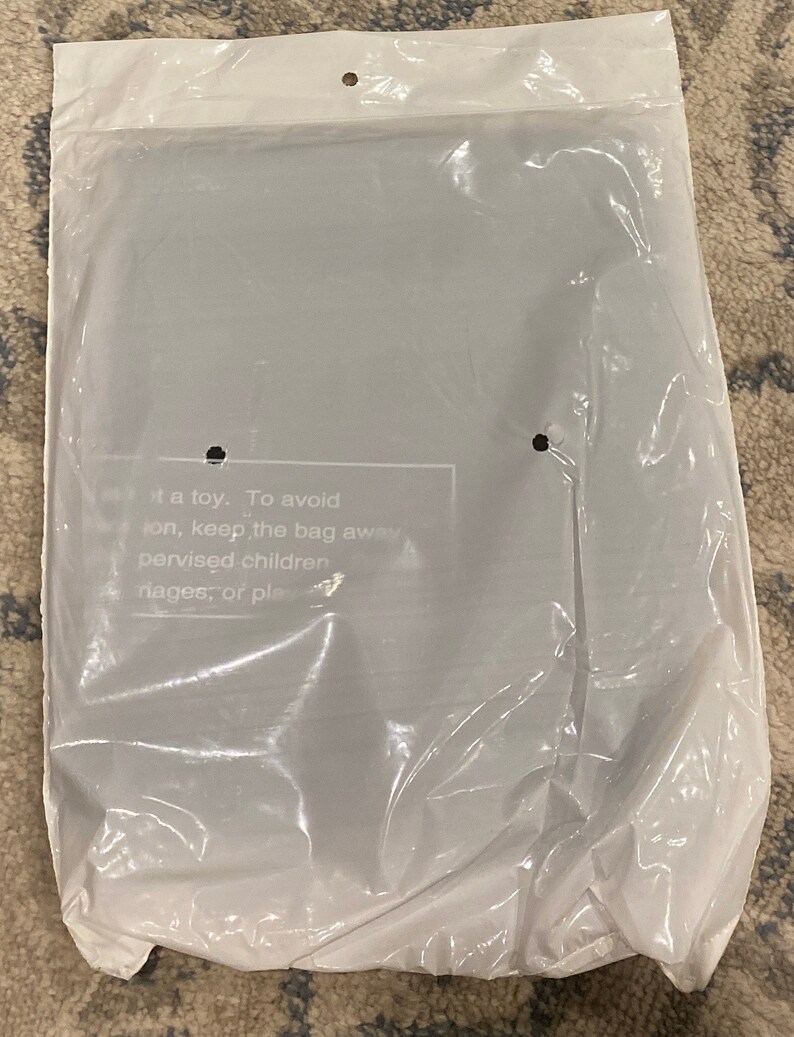 May include: A sealed, clear plastic bag with a white top. The bag contains an item that is not visible. Text on the bag reads: "...it a toy. To avoid...pervised children..."