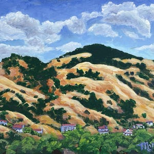 May include: An oil painting of rolling golden hills dotted with dark green trees and small houses with red roofs under a bright blue sky with white clouds. The landscape features a signature in the bottom right corner that reads Marnie.