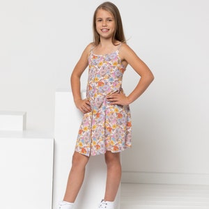 Peut inclure: Une jeune personne portant une robe sans manches à imprimé floral avec un devant boutonné et des baskets blanches.