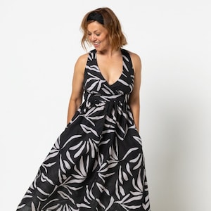 May include: A black and white floral print midi dress with a V-neckline and sleeveless design. The dress has a fitted bodice and a flowy skirt.