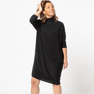 May include: A black mock neck dress with long sleeves. The dress is fitted in the shoulders and has a loose, flowing fit from the waist down.