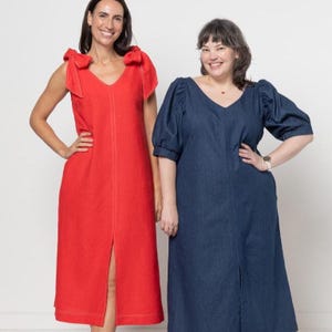 Può includere: Due donne con abiti. Una indossa un abito rosso con dettagli a fiocco sulle spalle e uno spacco frontale. L'altra indossa un abito blu scuro con maniche a sbuffo e uno spacco frontale. Entrambi gli abiti hanno uno scollo a V.