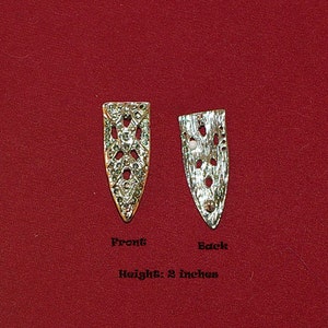 May include: A pair of silver metal decorative pieces with a geometric design. The pieces are 2 inches tall and are shown from the front and back.  Front and Back.